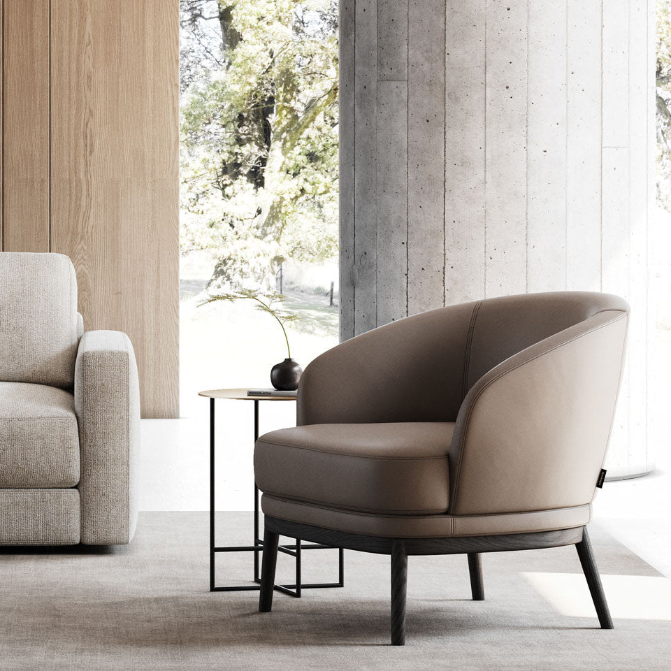 Modern living room with a beige sofa and armchair in a well-lit room.